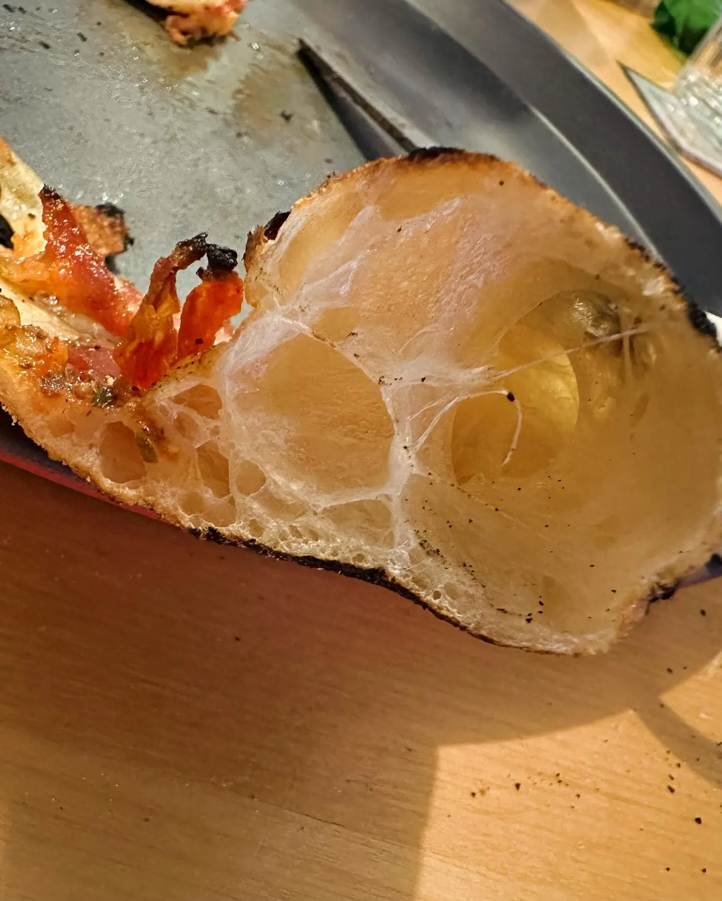 Comparaison côte à côte : coupe d'une pâte dense sans alvéoles (faible hydratation) vs une pâte aérée et alvéolée (65% d'hydratation)